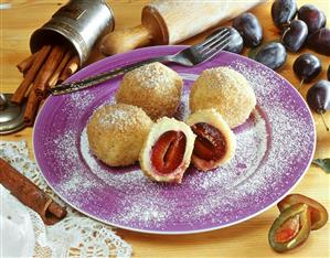 Damson dumplings with icing sugar on plate