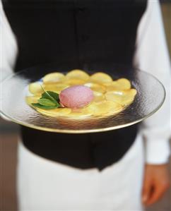 Waitress carrying plate of ice cream on nectarine carpaccio