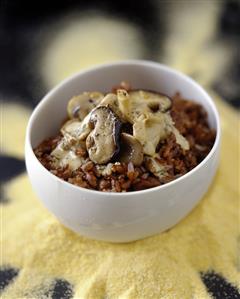 A bowl of red rice with mushrooms