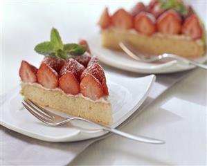 Two pieces of strawberry gateau with lime cream on plates