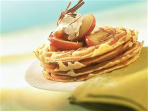 Several apples waffles with apple wedges and cinnamon cream