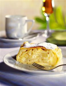 A piece of apple & curd cheese strudel & a cup of coffee