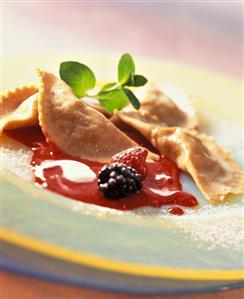 Wholemeal ravioli with apple filling on raspberry puree