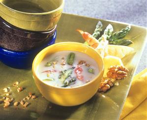 Creamed cheese soup with green asparagus and shrimps