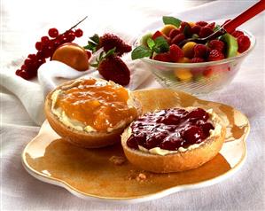 Two bread roll halves with apricot & strawberry preserve