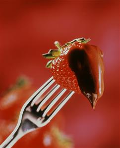 A chocolate-coated strawberry on a fork