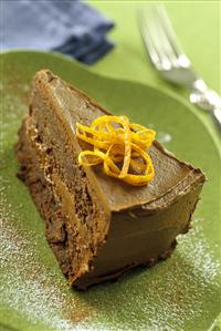 A piece of chocolate orange cake with orange zest