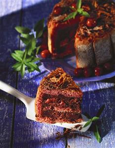 Chocolate cherry gateau, with a piece on cake slice