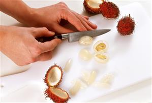 Loosening the flesh of a rambutan from the stone