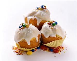 Three muffins with icing and coloured chocolate beans