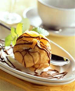 Scoop of ice cream in pastry case with chocolate icing