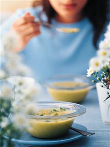 Young woman eating potato soup