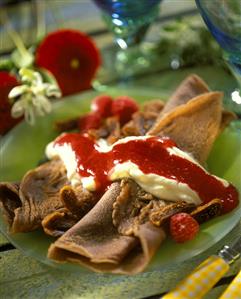 Chocolate pancakes with vanilla mousse and raspberry sauce