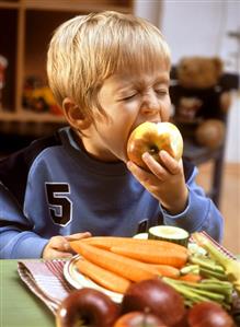 Small boy eating an apple