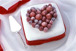 White cake with raspberry heart, cake slice beside it