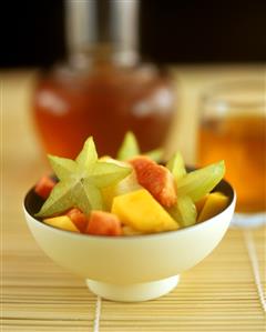 Fruit salad with carambola stars in bowl