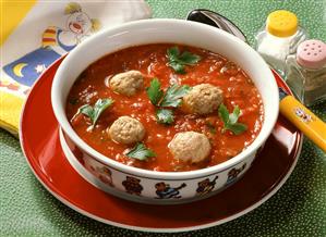 Tomato soup with sausage dumplings, served in child's plate