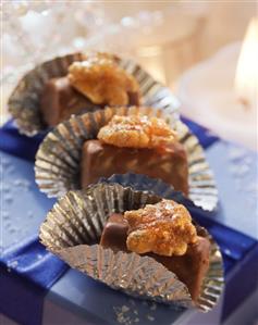 Three walnut chocolates on a gift box