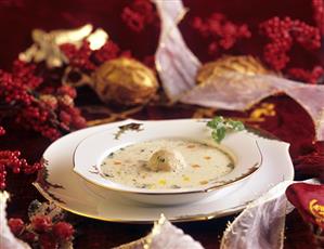 Creamed goose soup with soup dumplings on Christmassy plate