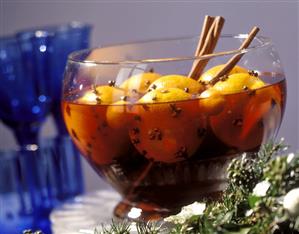 Christmas punch with whole oranges in glass bowl