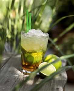 Glass of Caipirinha on a wooden table in open-air