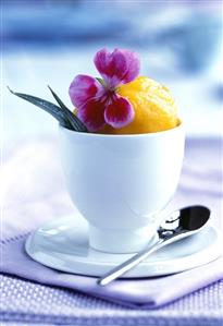 Apricot sorbet in a beaker with flower