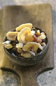 Terracotta bowl of mixed candied fruit on wooden board