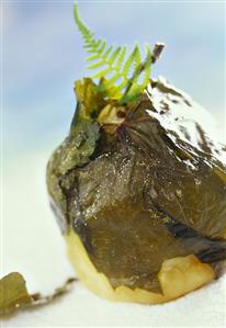 Poached apple in vine leaves