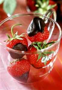 Fresh, chocolate-dipped strawberries in glass cup