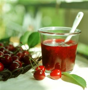 Cherry jam in jar, fresh cherries beside it