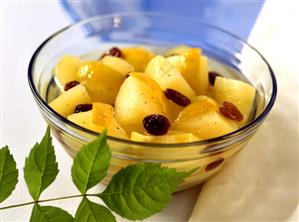 A bowl of apple compote with raisins and lemon rind