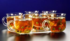 Broth with vegetables in glass cups