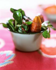 Corn salad with fried apple and bacon in a dish