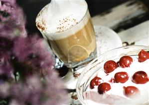 Glass of latte macchiato and quark dessert with cherries (1)