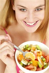 Young woman with a bowl of fruit salad