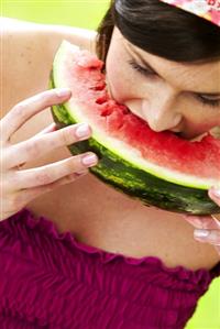 Woman biting into a piece of watermelon (2)