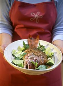 Woman holding platter of barbecued red snapper (1)