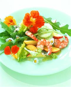 Colourful salad with apples, shrimps and edible flowers