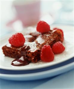 Piece of chocolate cake with raspberries and chocolate sauce