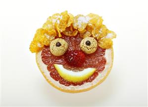 Face made from fruit, cornflakes and amarettini