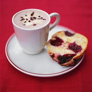 A cup of chocolate and a piece of blackberry muffin