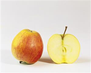 One half and one whole Rubinette apple