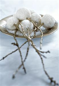 Almond coconut balls stuck on branches