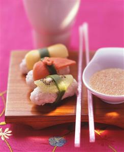 Sushi with fruit and sesame and honey dip