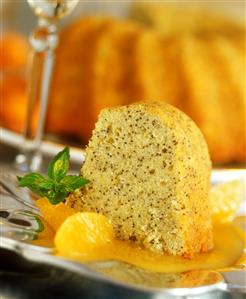 A piece of orange cake on orange sauce