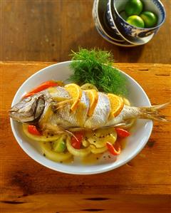 Sea bream with slices of orange on vegetables