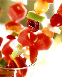 Fresh fruit kebabs sticking out of a glass