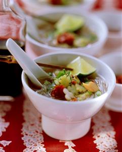 Spicy Asian soup with rice noodles & vegetable flowers in bowl