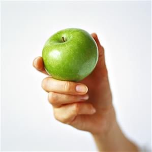 Hand holding a green apple