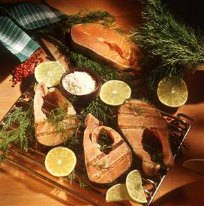 Barbecued salmon steaks on rack beside salt and limes